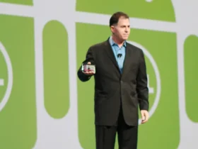 Michael Dell standing on stage at Oracle OpenWorld in front of large Android logos