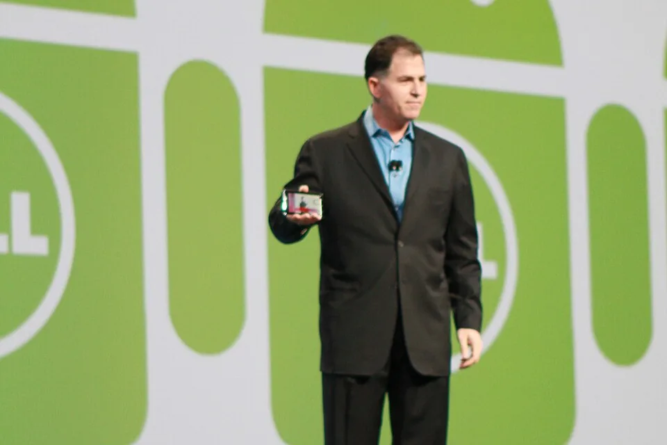Michael Dell standing on stage at Oracle OpenWorld in front of large Android logos