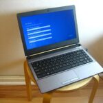 A laptop on a stool showing the first-run Windows setup screen