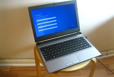 A laptop on a stool showing the first-run Windows setup screen