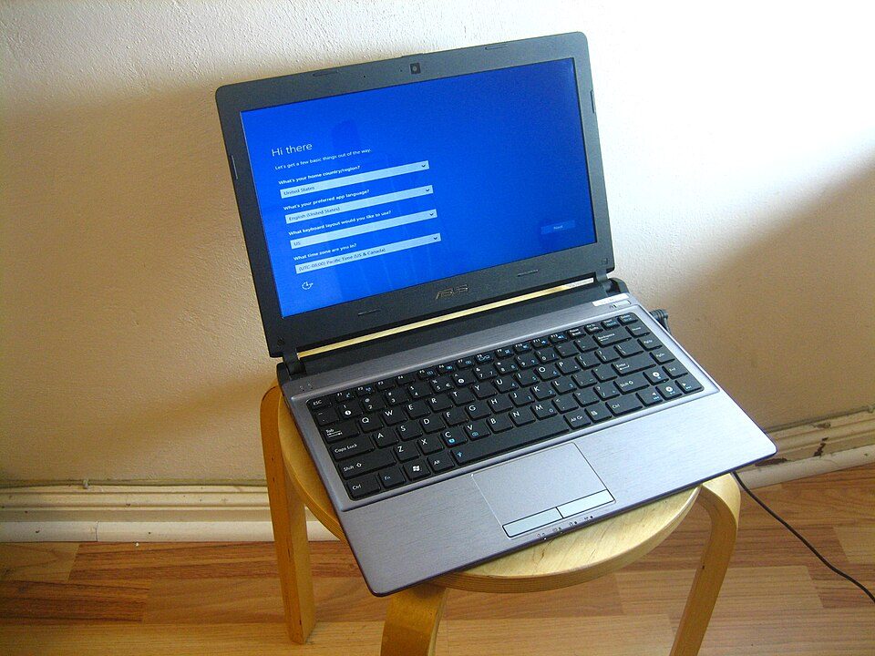 A laptop on a stool showing the first-run Windows setup screen