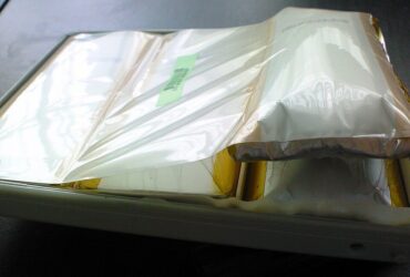A swollen MacBook Pro battery pack with its foil pouch ballooned inside the casing