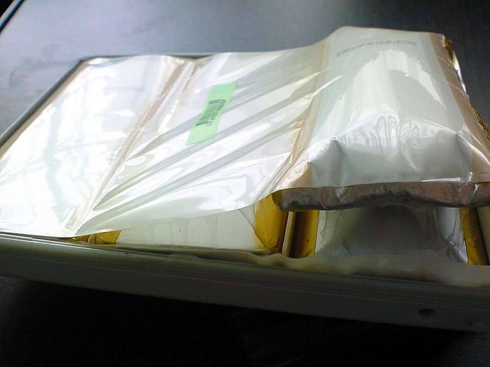 A swollen MacBook Pro battery pack with its foil pouch ballooned inside the casing